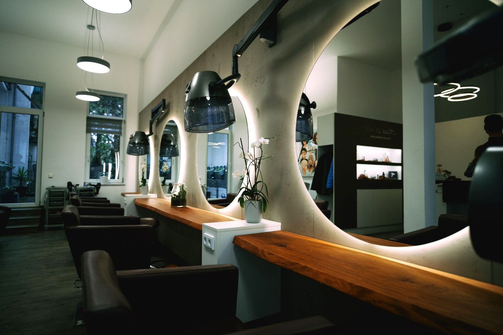 Stilvolles Salon-Interieur mit runden Spiegeln, moderner Beleuchtung und gemütlichen Sesseln